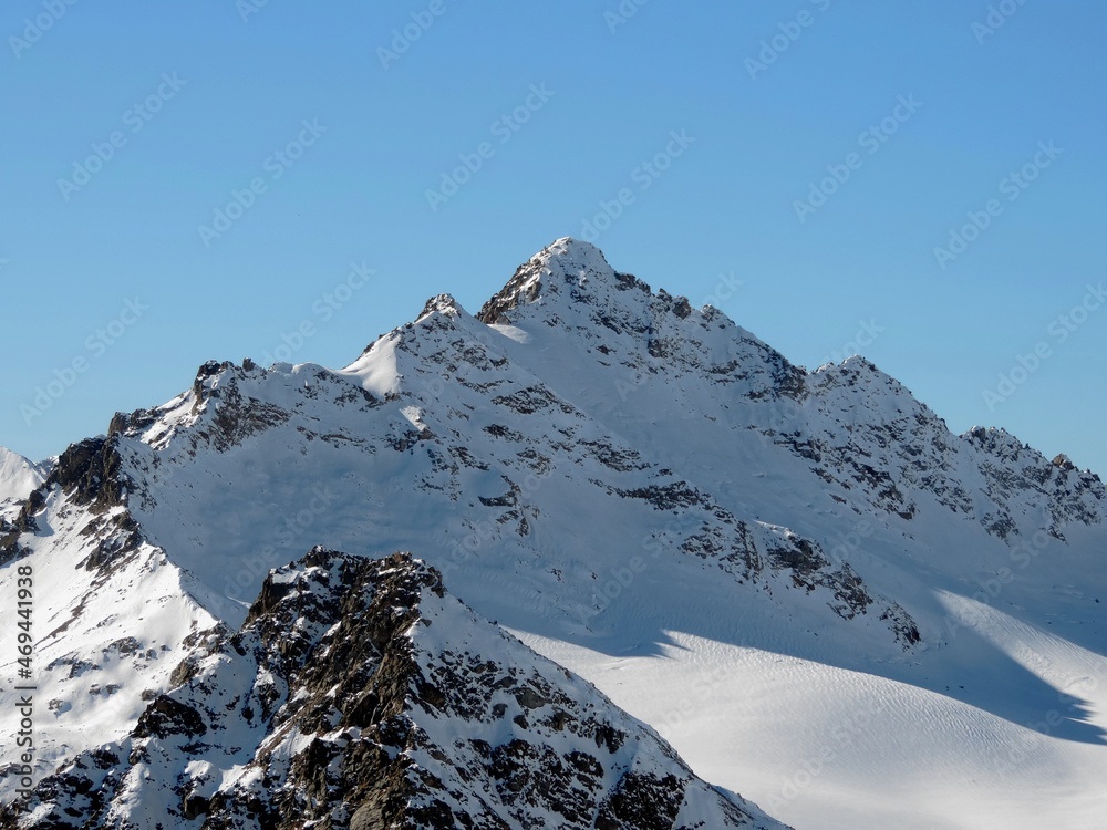 Snow capped mountains, blue sky on a clear day. Mountain view from Elbrus. Mountain top.