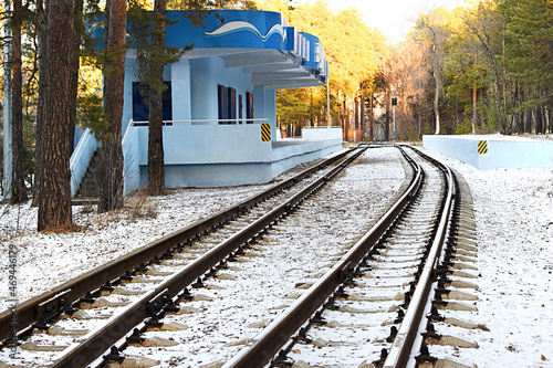 Empty railway track and empty train station in the winter forest. Selective focus.
