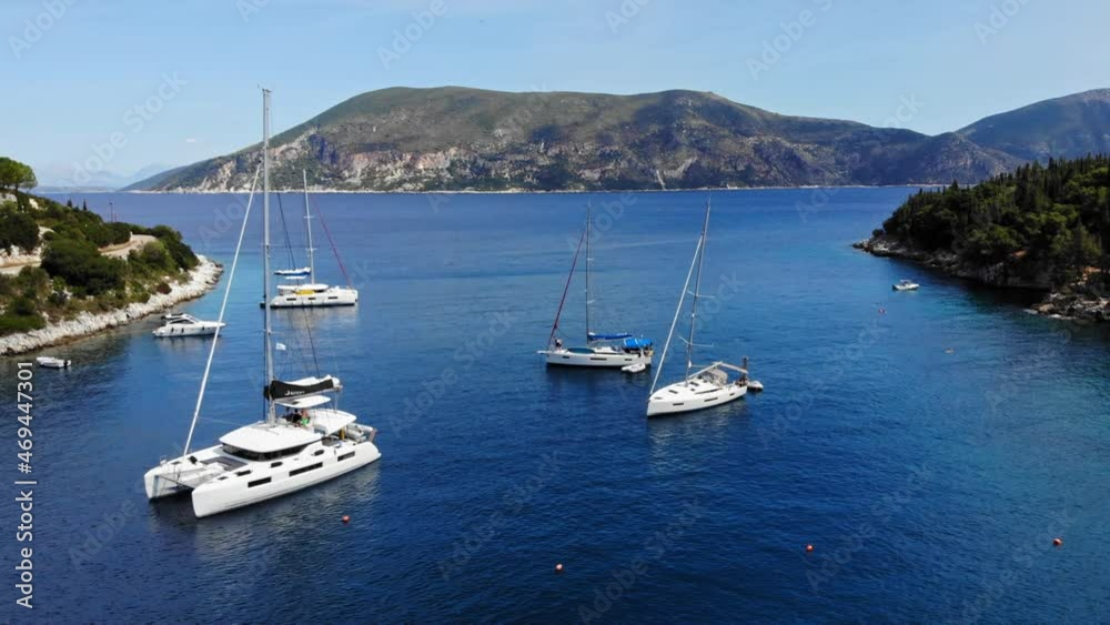 Catamaran And Sailboats In The Ionian Sea At The Foki Beach In The Island Of Kefalonia In Greece. aerial sideways Catamaran And Sailboats In The Ionian Sea At The Foki Beach In The Island Of Kefalonia In Greece. aerial sideways