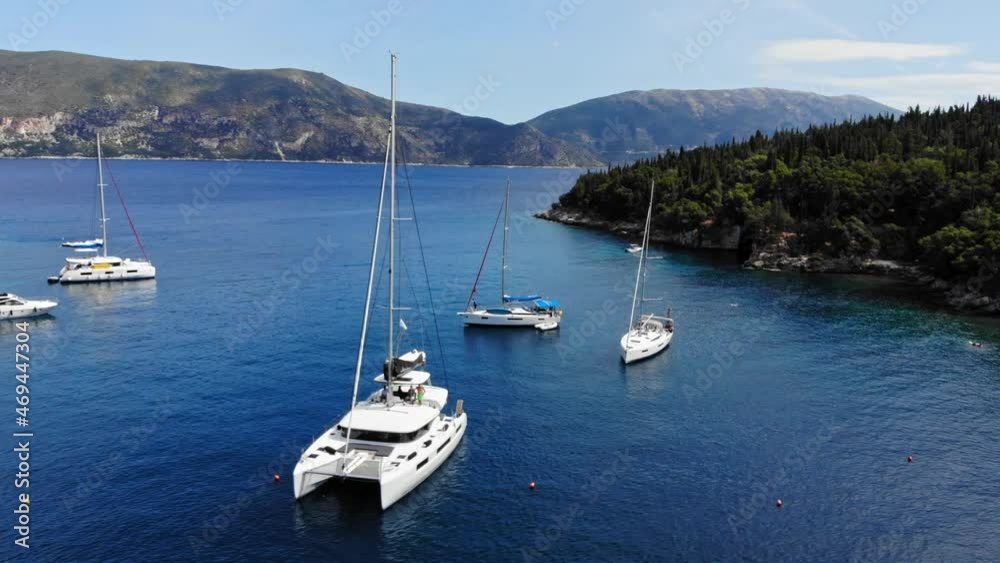 Luxury Boats And Yachts Anchored At The Crystal Blue Waters Of Foki Beach In Kefalonia, Greece. aerial Luxury Boats And Yachts Anchored At The Crystal Blue Waters Of Foki Beach In Kefalonia, Greece. aerial