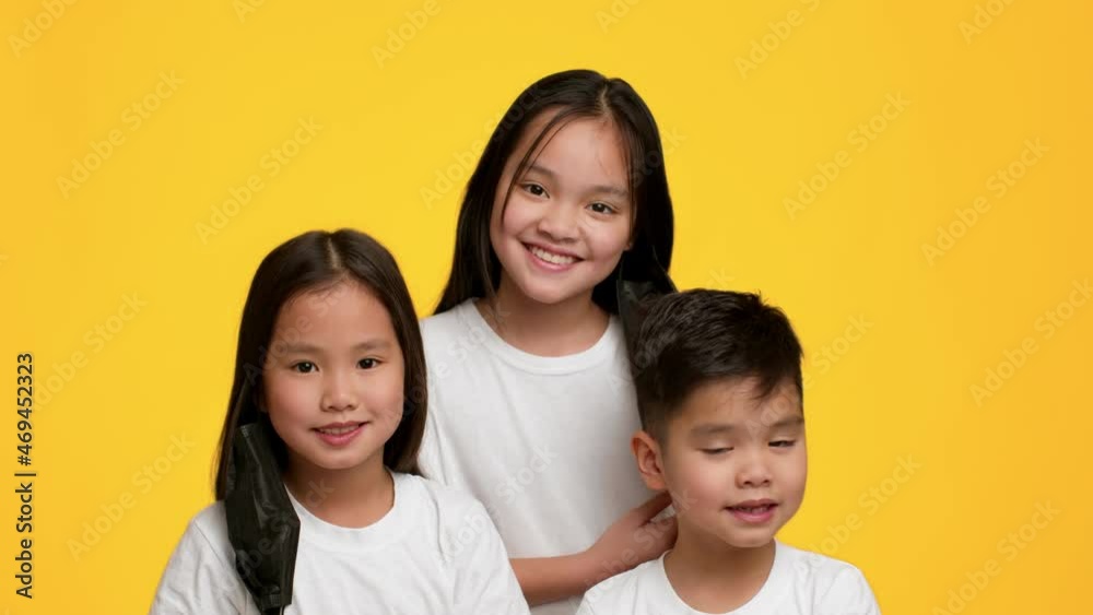 Asian Kids Taking Off Face Mask Smiling Over Yellow Background Asian Kids Taking Off Face Mask Smiling Over Yellow Background