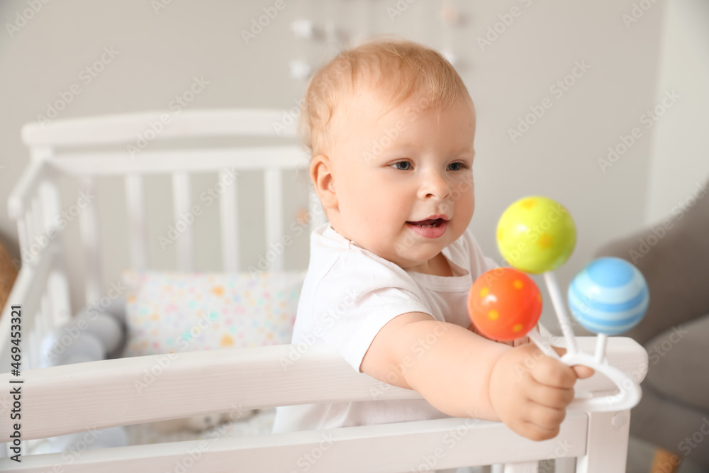Adorable little baby with toy in crib Adorable little baby with toy in crib
