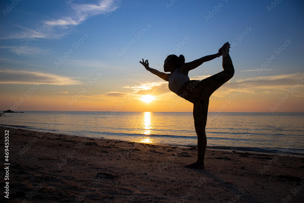 A fit young man practices yoga poses on the beach during sunset. Meditation  and concentration posture on the sea side of relaxing day at dawn  surrounding by nature. Photos | Adobe Stock