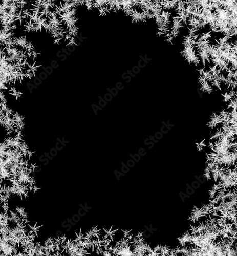 A frame of a frosty pattern of ice crystals on a black background. A frame with an abstract ice structure allows you to apply or add a frost effect. Frost on the glass, freezing effect