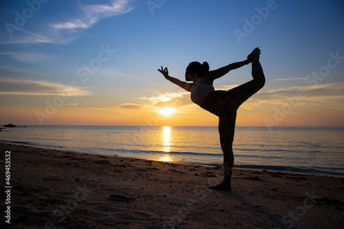 Standing Bow pose. Asian woman doing yoga poses on a beach in Koh Pha Ngan island  Thailand