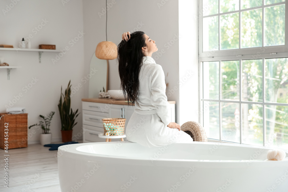 Relaxed young woman in bathrobe after taking bath at home Relaxed young woman in bathrobe after taking bath at home