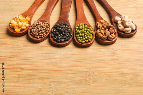 various dried types of bean and pea in wooden spoon.