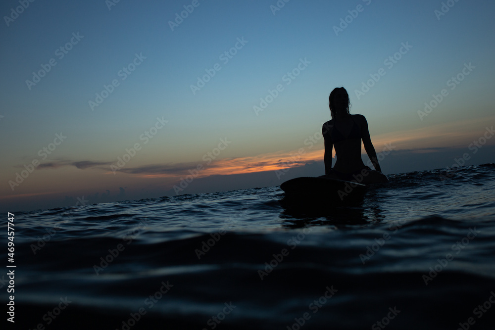 beautiful girl with a surfboard at sunset.