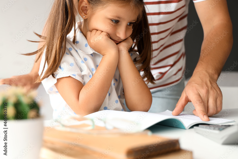 Man helping his little daughter to do lessons at home Man helping his little daughter to do lessons at home