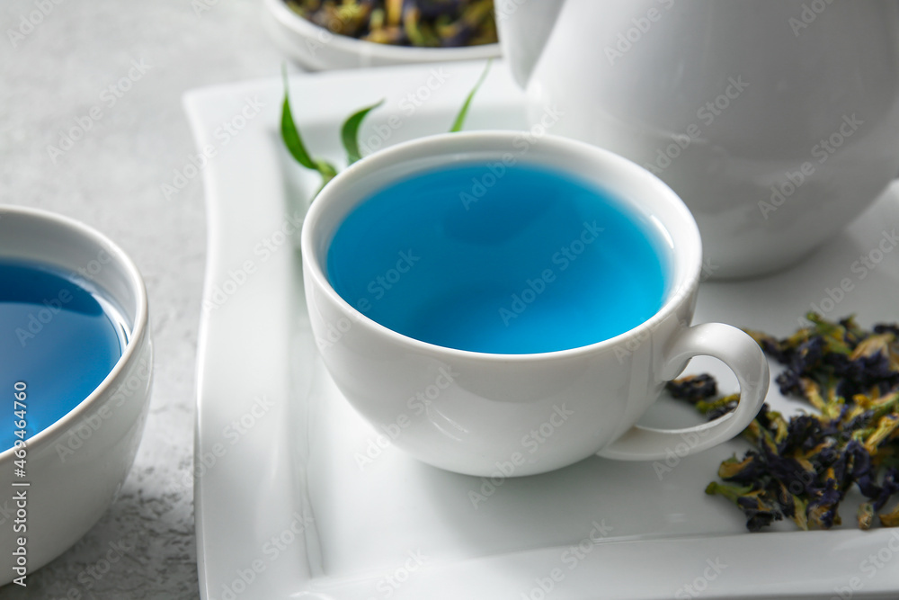 Cup of organic blue tea and dried flowers on table, closeup Cup of organic blue tea and dried flowers on table, closeup