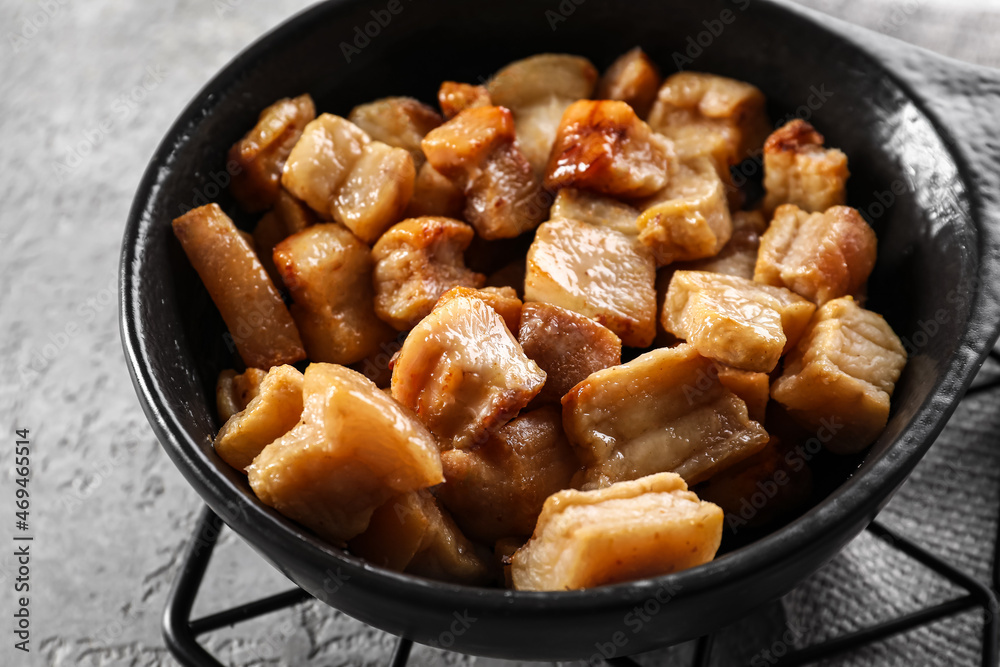 Frying pan with tasty cracklings on light background Frying pan with tasty cracklings on light background
