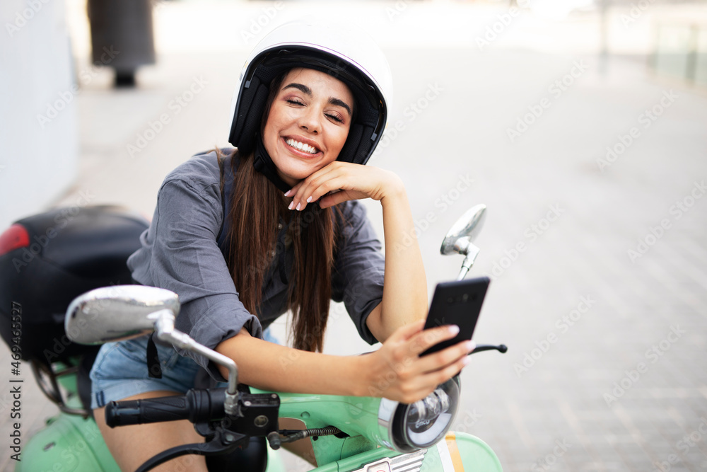  Beautiful woman getting ready for a ride on scooter. Beautiful happy lady using the phone