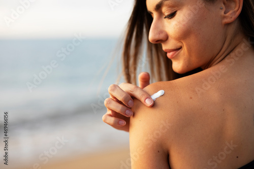 Woman using sunscreen cream. Beautiful girl with sun protection cream..