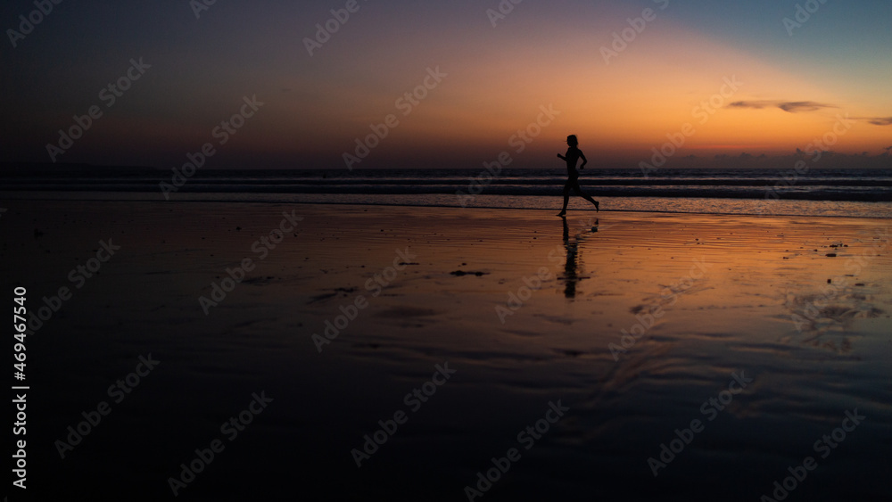 beautiful girl runs along the beach at sunset