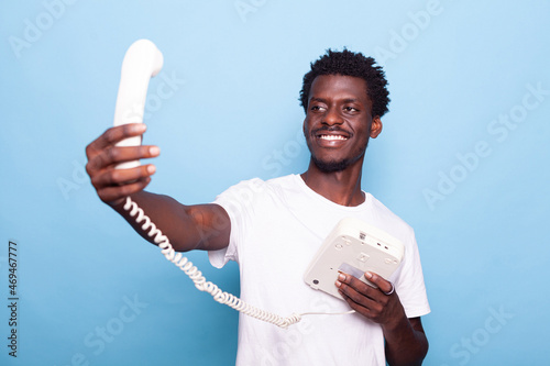 Billede på lærred African american man pretending to take selfie on old landline phone