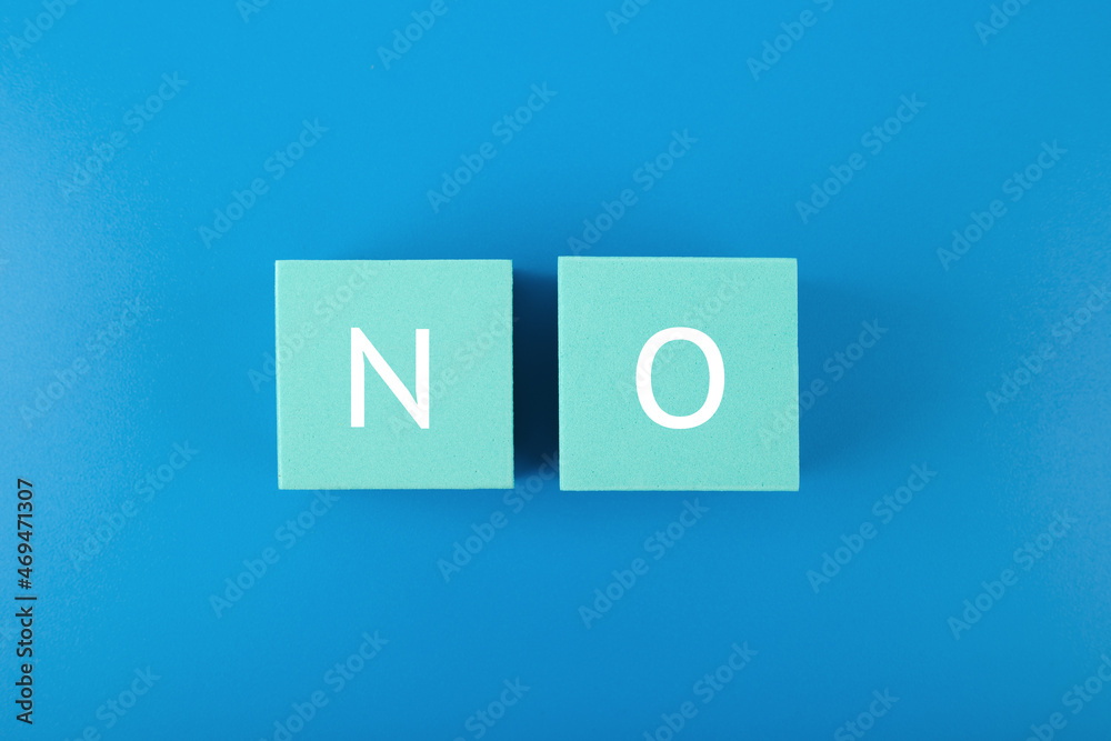 Say no or negative answer minimal concept on blue background. No written on toy cubes Say no or negative answer minimal concept on blue background. No written on toy cubes