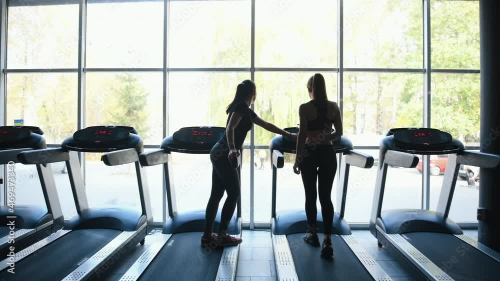 Rear view of female trainer that shows to girl how to use racetrack Rear view of female trainer that shows to girl how to use racetrack