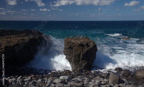 Gran Canaria, north west coast around natural swimming pools Salinas de Agaete, 
waves breaking against old eroded dark lava platform
 photo
