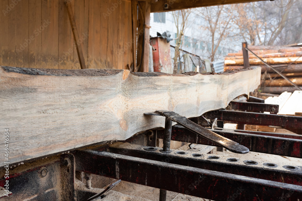 Timber material processing and cutting at sawmill. Sawing machine at wood production factory. Timber material processing and cutting at sawmill. Sawing machine at wood production factory.