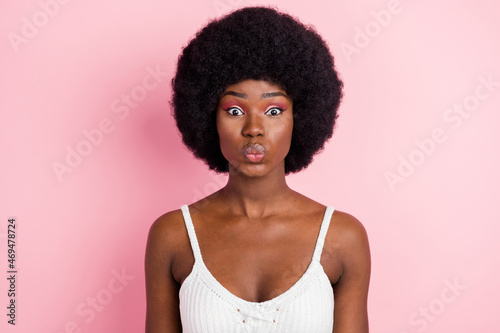 Photo of flirty young brunette hairdo lady blow kiss wear white top isolated on pastel pink color background © deagreez