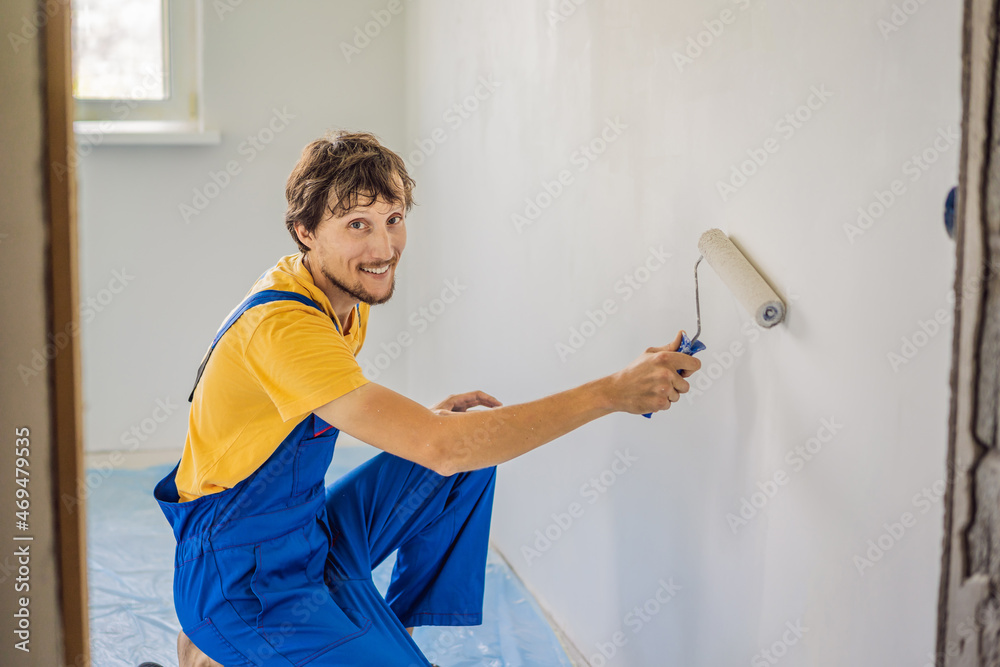 Professional painter worker painting and priming wall with painting roller