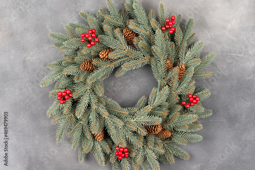 Advent Christmas wreath on gray table decoration. Christmas wreath with red berries and pine cone