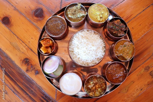 Dham - Traditional food of Himachal Pradesh. Himachali kangri dham thali includes Kaddu ka khatta, Chane ka Madra, sepu vadi, maash dal, Rajma, salad, rice, or Mitha Bhaat. served with Roti and pickle photo