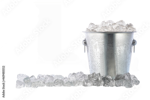 Full metal bucket with ice cubes and pieces of crushed ice isolated on white background.