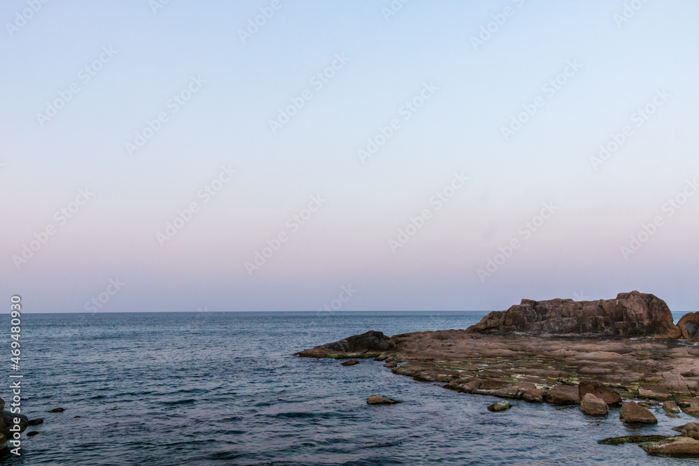 The sunset and the sea view and stones.