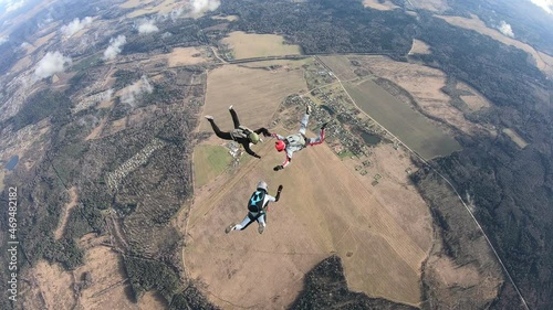 Skydiving. Formation jump. Three skydivers are training in the sky.