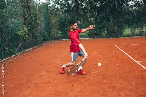 man playing tennis outdoor on clay court