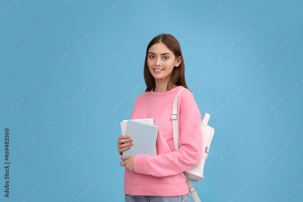 Teenage student with books and backpack on turquoise background Teenage student with books and backpack on turquoise background