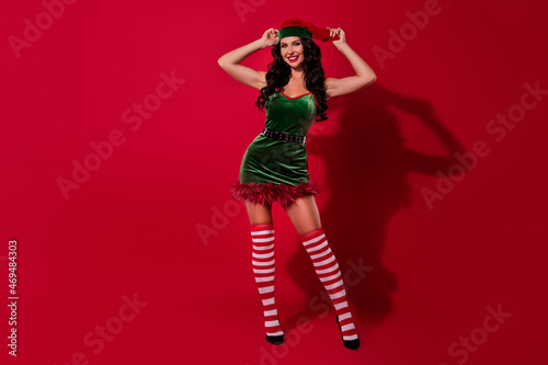 Photo of charming stunning young santa helper wear elf dress headwear smiling isolated red color background © deagreez