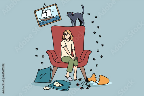 Mess and disorder from cat concept. Young frustrated girl sitting on armchair looking at broken vase and prints on wall from her cat vector illustration 