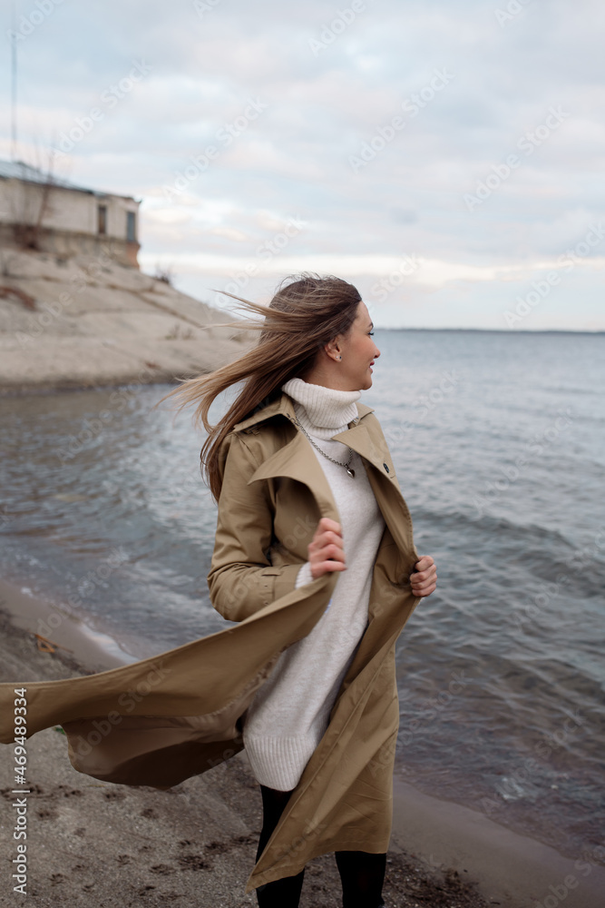 Young caucasian woman walking on the beach in autumn Young caucasian woman walking on the beach in autumn