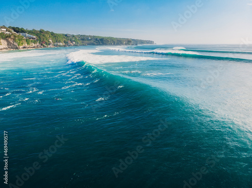 Aerial view in Bali with surfers and turquoise barrel wave. © artifirsov