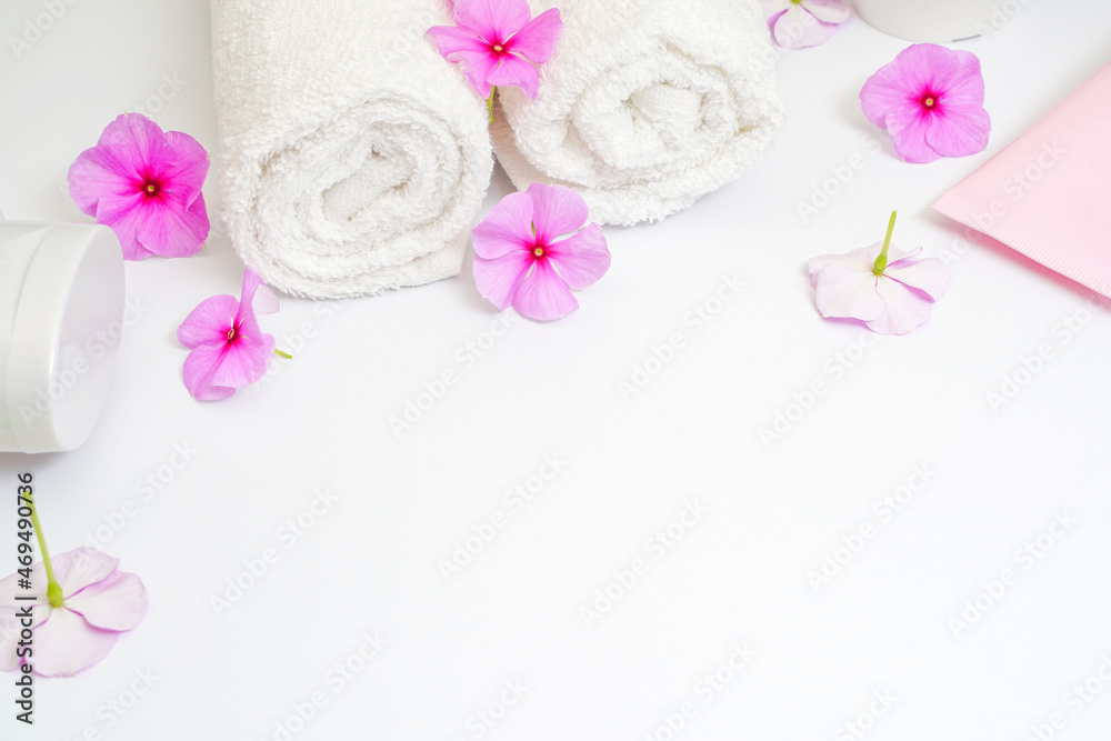 Clean white rolled towels with flowers on white copy space for text frame Clean white rolled towels with flowers on white copy space for text frame