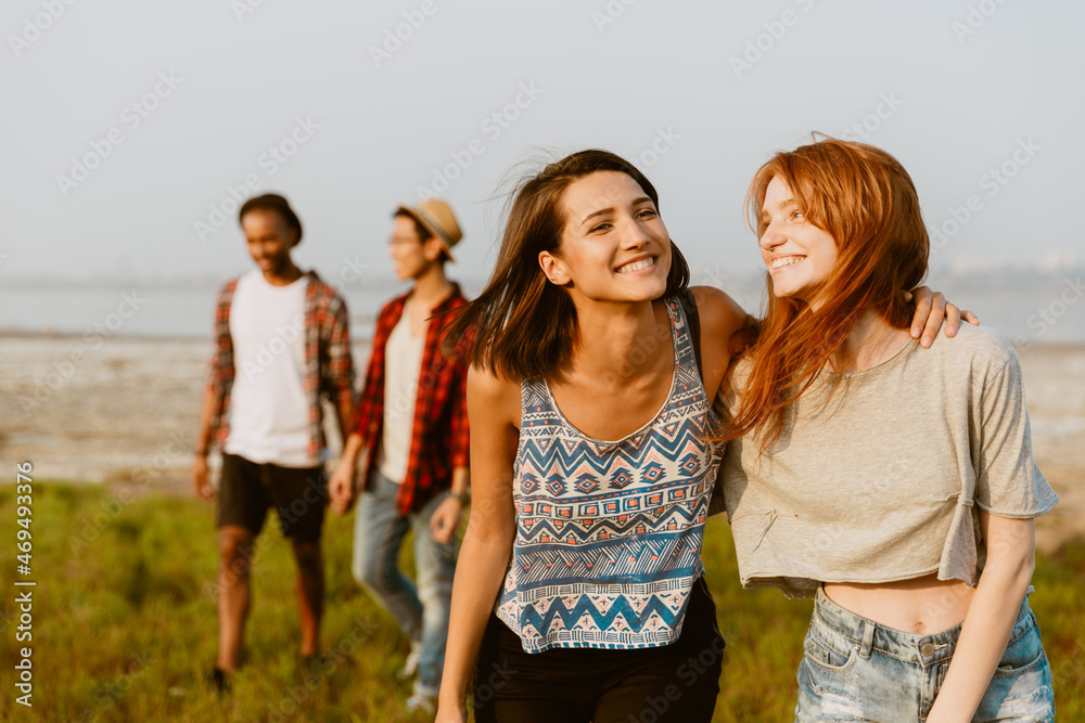 Young multiracial friends hugging and smiling together Young multiracial friends hugging and smiling together