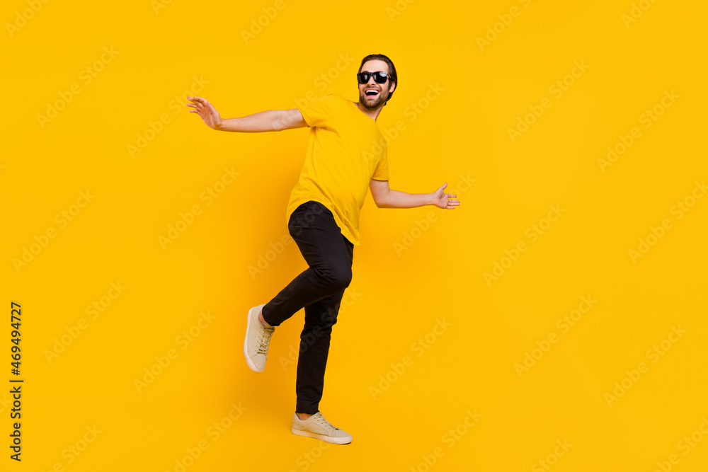Full body profile side photo of young man have fun eyewear clubber isolated over yellow color background