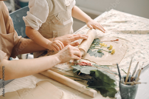 Portrait of mother and little girl shaping clay together photo