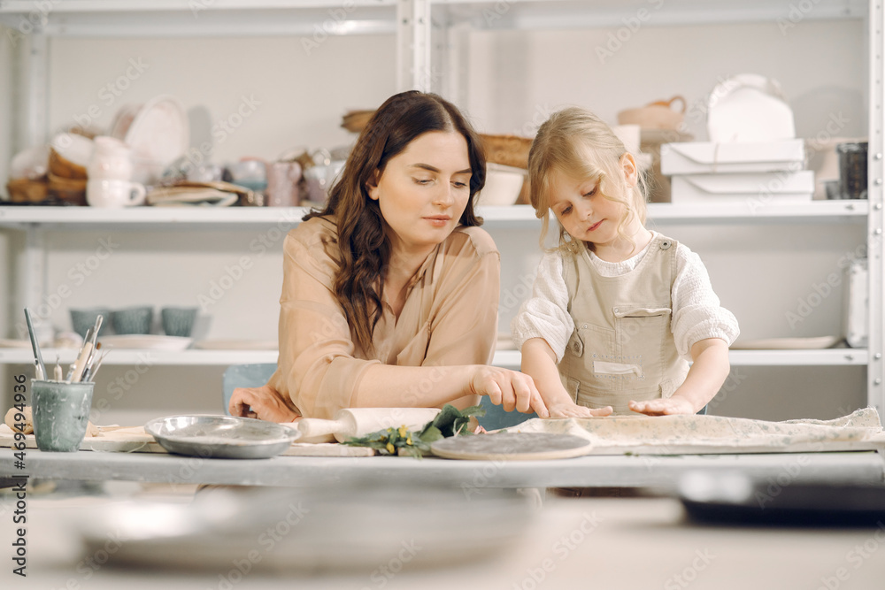 Portrait of mother and little girl shaping clay together Portrait of mother and little girl shaping clay together