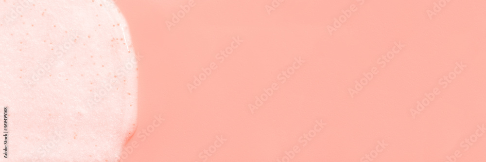 The texture of a scrub or shower gel on a pink background.