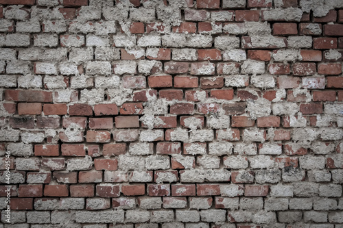Brick wall with remnants of plaster and cement rendering, color graded
