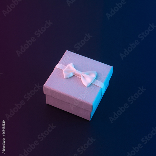 Holiday gift box with ultra violet colors.Vaporwave dark background.
