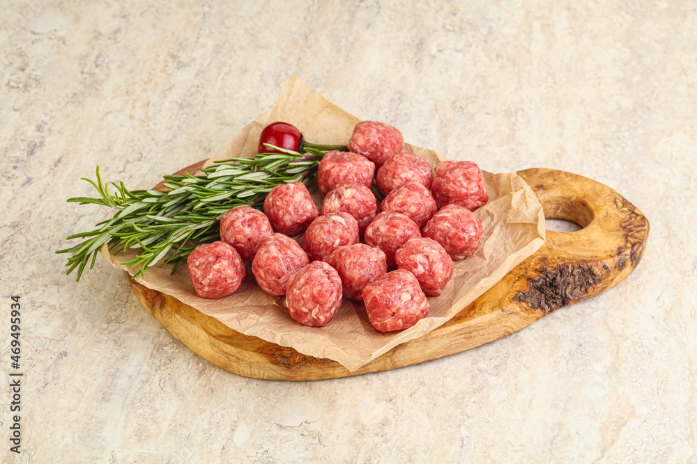 Raw uncooked beef meatballs served rosemary Raw uncooked beef meatballs served rosemary
