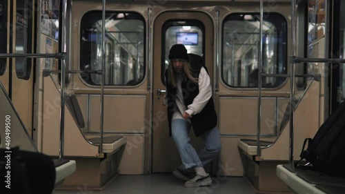 Brave active teenage girl dancing in metro alone, showing talent in front of everybody, performing street dance break dance or hip hop