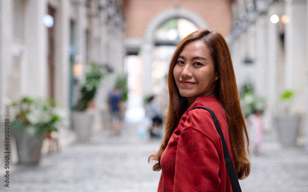 Fototapeta premium Portrait of a young asian woman while traveling and sightseeing around the city