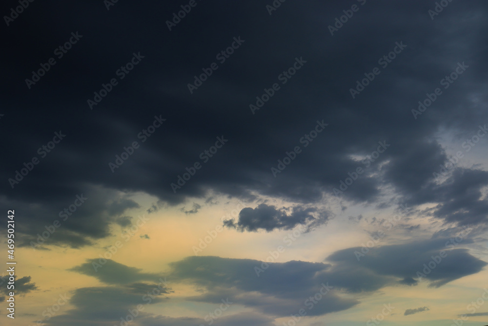 Stormy sky full of dark clouds, covering the sunset light, before the rain.