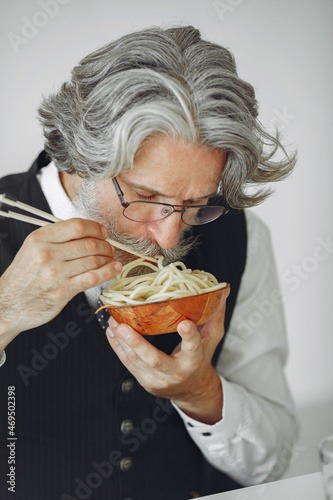 Handsome pensive mature businessman with pasta