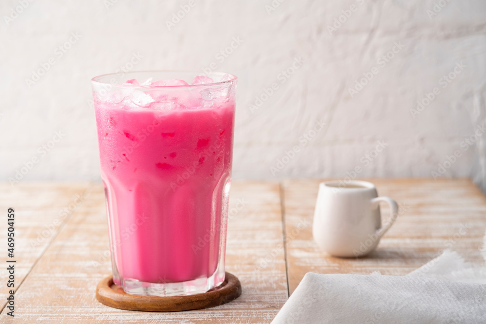Thai style iced pink milk.Cold sweet drink Red Grenadien Sugar Syrup mix with milk and iced cube in glass Thai style iced pink milk.Cold sweet drink Red Grenadien Sugar Syrup mix with milk and iced cube in glass
